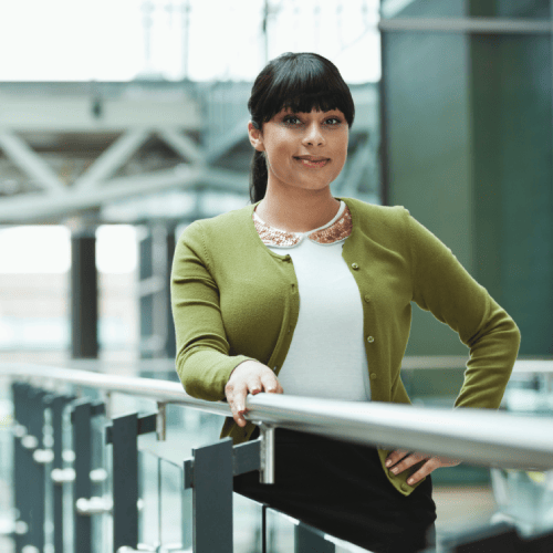 Bewerberin im Finanzbereich im Business-Look am Geländer stehend