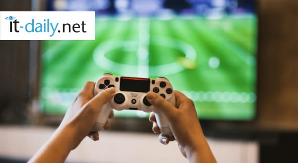 Hände halten Gaming-Controller vor einen großen Bildschirm